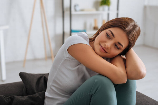 молодая веселая женщина расслабляется в гостиной
 