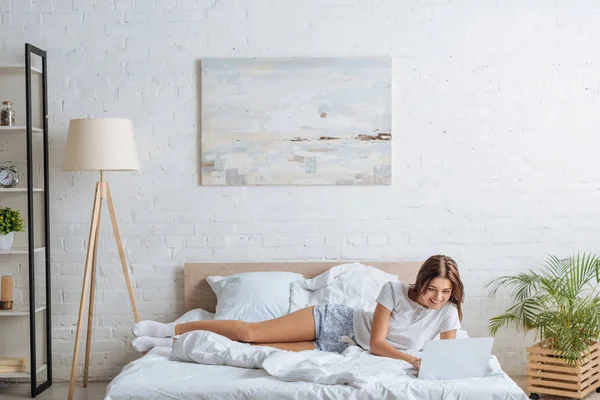 Mujer Feliz Usando Ordenador Portátil Mientras Relaja Dormitorio —  Fotos de Stock