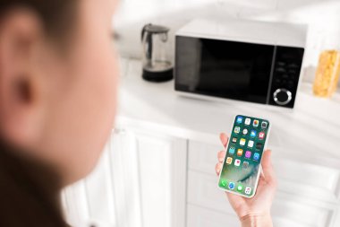 KYIV, UKRAINE - OCTOBER 9, 2019: cropped view of woman holding smartphone with apple interface