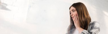 panoramic shot of shocked and attractive woman looking away 