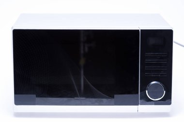 Beyaz zemin üzerinde metal ve elektrikli mikrodalga fırın 