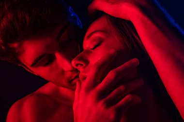 ateşli çıplak seksi adam kırmızı ışıkta bir kadını öpüyor.