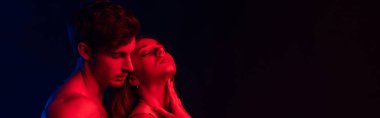 Tutkulu, çıplak seksi, kırmızı ışıktaki genç çift siyah, panoramik çekimde izole edilmiş.