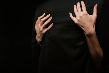 Siyahta izole edilmiş, kucaklaşan erkek arkadaşı olan bir kadın. 
