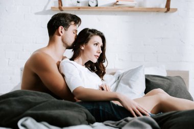 Evde çekici bir kızın başını öpen adamın seçici odağı. 