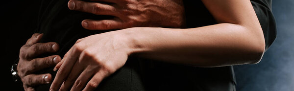 панорамный снимок мужчины, обнимающего женщину на черном с дымом
