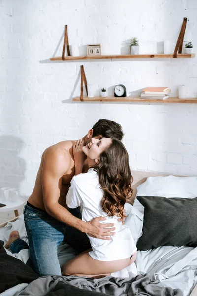 Muscular Boyfriend Hugging Cheerful Girl While Sitting Bed — Stock Photo, Image