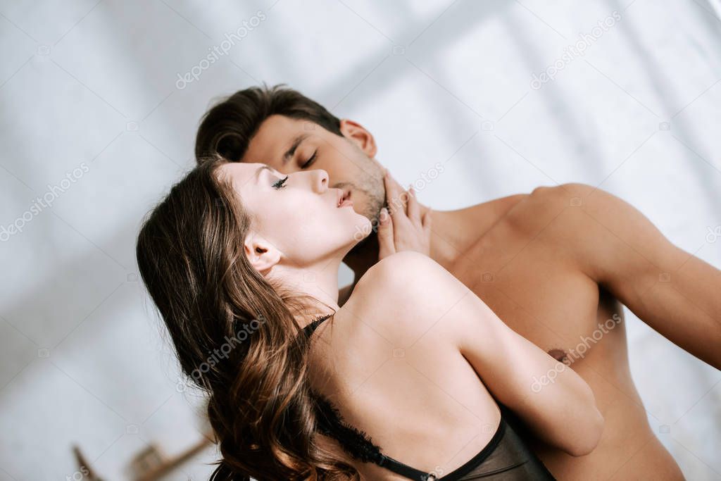 low angle view of girl touching muscular boyfriend 