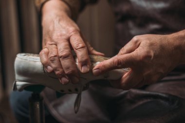 Shoemaker 'ın atölyede ayakkabıyı tamir edişinin kırpılmış görüntüsü