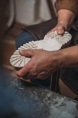 Ayakkabı tamircisinin atölyedeki tabanı tamir ederken kısmi görünümü