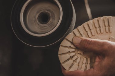 Öğütme makinesinde ayakkabı cilalayan ayakkabıcıların kısmi görüntüsü