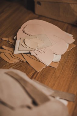 Atölyedeki ahşap masa üzerindeki deri detaylarının seçici odağı
