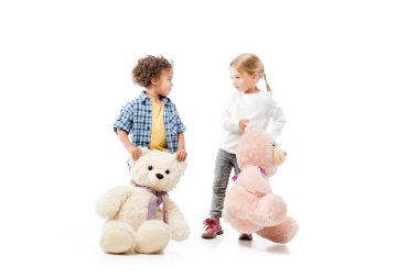 cute multicultural kids holding teddy bears, on white  clipart