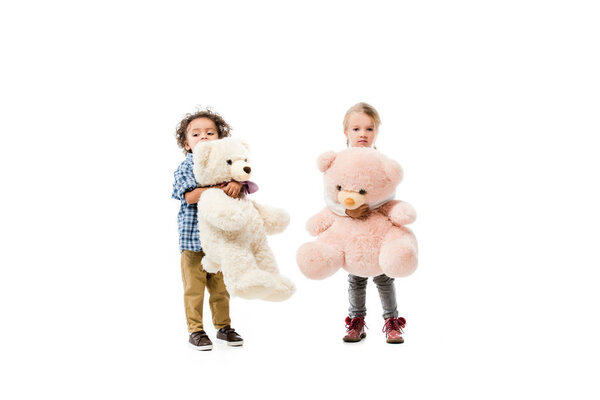 мультикультурные дети держат плюшевых медведей, изолированных на белом
 