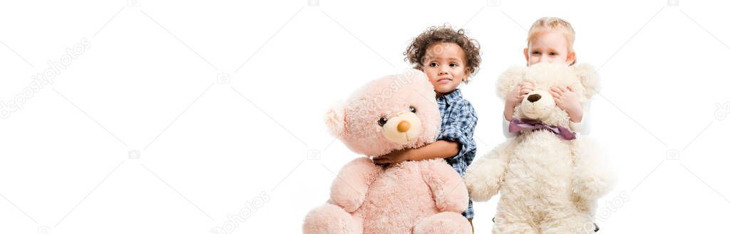 panoramic shot of adorable multiethnic children holding teddy bears,  isolated on white 