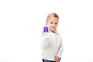 Kyiv, Ukrayna - 18 Kasım 2019: Sevimli bir çocuk ekranda elma müzik uygulaması ile akıllı telefon gösteriyor, beyaz ekranda izole edilmiş.