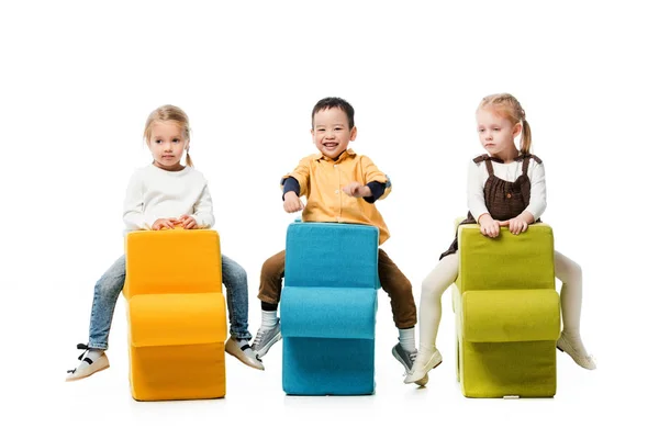Multiethnische Kinder Sitzen Auf Puzzlestühlen Isoliert Auf Weiß — Stockfoto