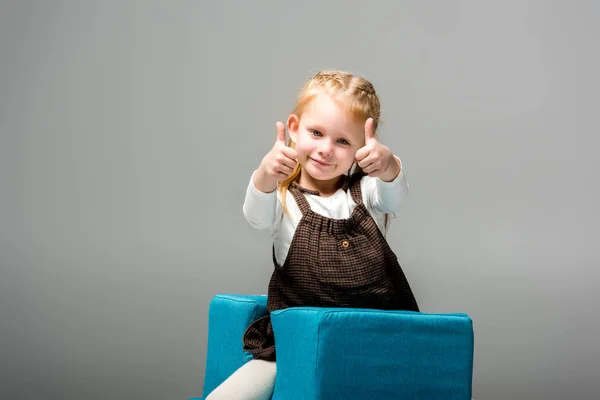 Щаслива Дитина Показує Великі Пальці Синьому Кріслі Головоломці Ізольовані Сірому — стокове фото