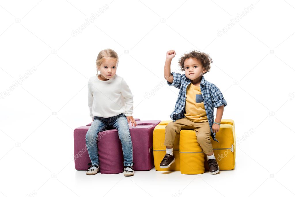 multicultural children sitting on puzzle chairs, on white