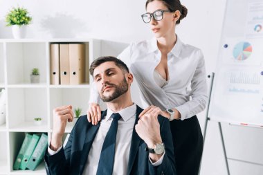 sexy secretary with big breast doing massage to businessman in office 