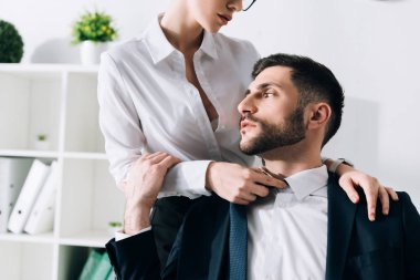 cropped view of secretary with big breast hugging handsome businessman in office 