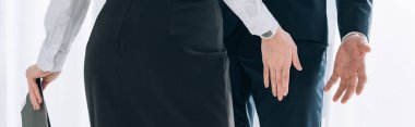 panoramic shot of secretary touching leg of businessman in office 