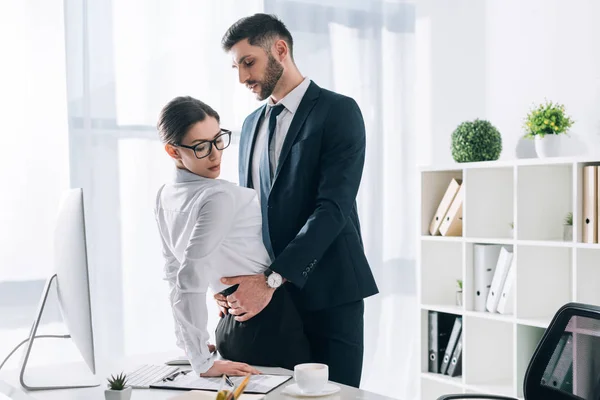 Guapo Hombre Negocios Abrazando Atractiva Secretaria Mesa Oficina — Foto de Stock