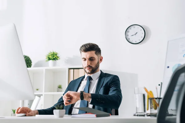 Zakenman Zit Aan Tafel Kijkt Naar Polshorloge Het Kantoor — Stockfoto