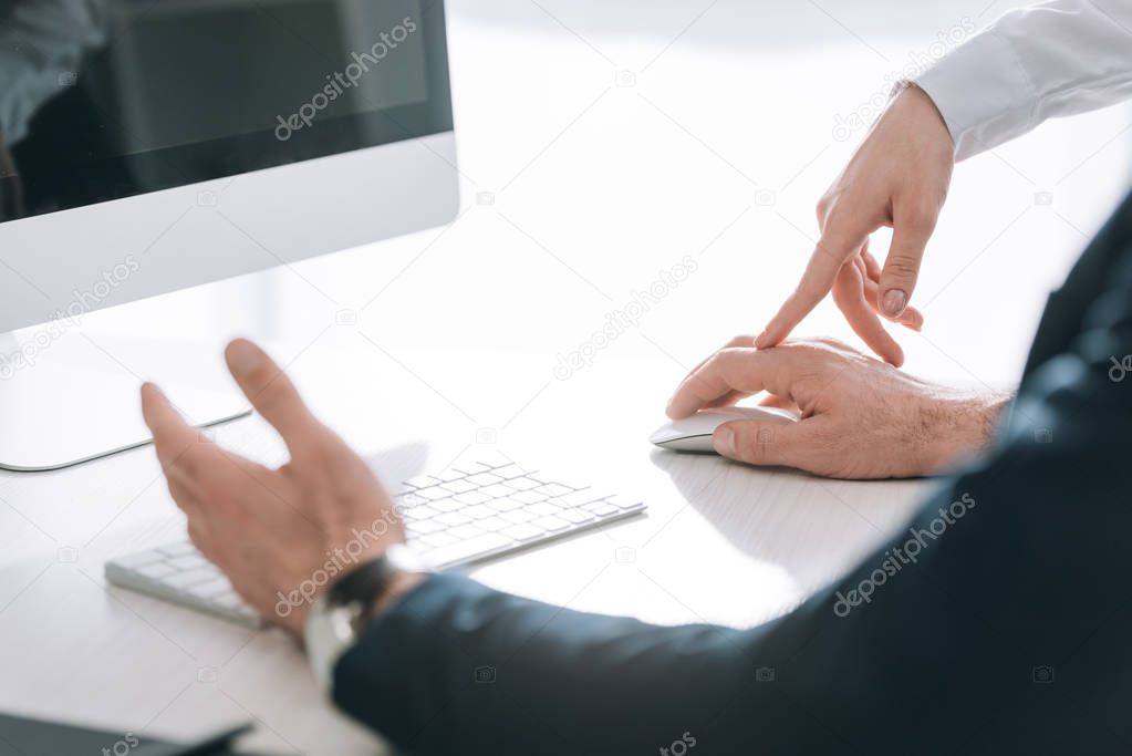 cropped view of secretary touching hand of businessman in office 