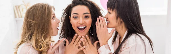 Panoramisch Shot Van Opgewonden Multiculturele Vriendinnen Fluisteren Roddelen Pyjamafeest — Stockfoto