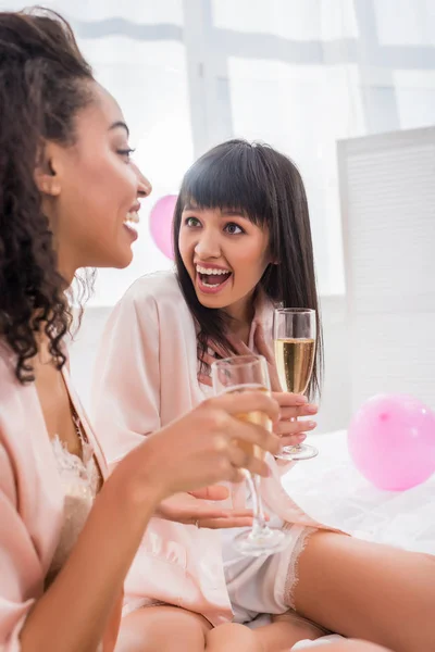 Surprised Multicultural Girlfriends Glasses Champagne Talking Pajama Party — Stock Photo, Image