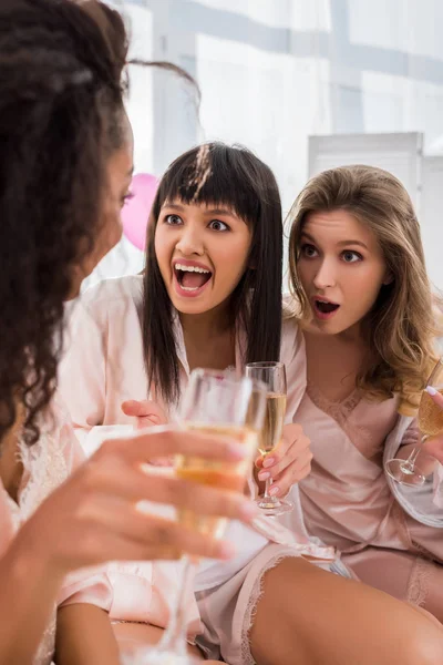 Шокированные Многонациональные Девушки Бокалами Шампанского Разговаривают Пижамной Вечеринке — стоковое фото