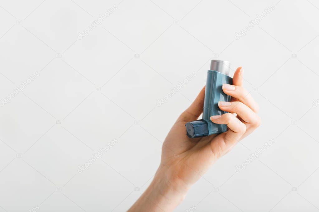 Cropped view of inhaler in female hand isolated on white