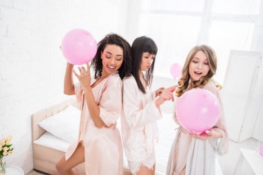 smiling multicultural girls dancing with pink balloons on bachelorette party clipart