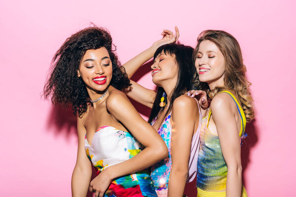 привлекательные модные многонациональные девушки танцующие на розовом
