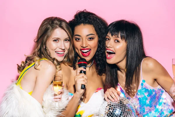 Happy Multiethnic Girlfriends Holding Champagne Glasses Disco Ball While Singing — Stock Photo, Image