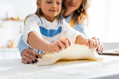 Anne ve gülümseyen kızın hamur işi pişirme görüntüsü. 