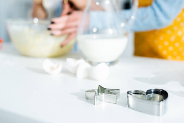 selective focus of dough molds on table in kitchen 