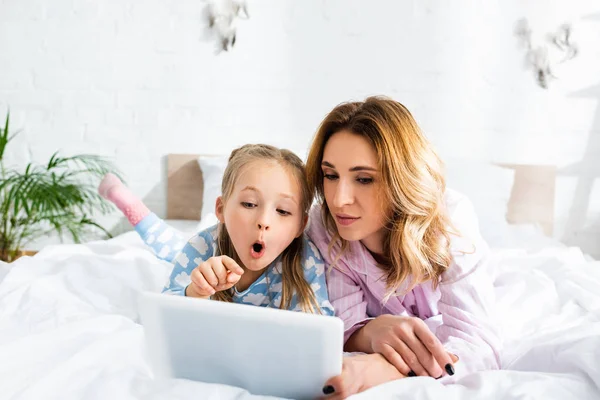 Mãe Atraente Filha Chocada Apontando Com Dedo Para Tablet Digital — Fotografia de Stock