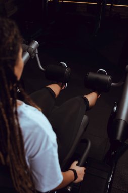 Afrika kökenli Amerikalı bir kadının spor salonunda karın kasları için egzersiz yaptığını gördüm.