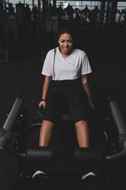 Afrikalı Amerikalı kadın spor salonunda karın kasları için egzersiz yapıyor.