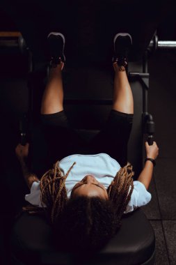 Dövmeli Afro-Amerikan kız spor makinesinde çalışıyor.