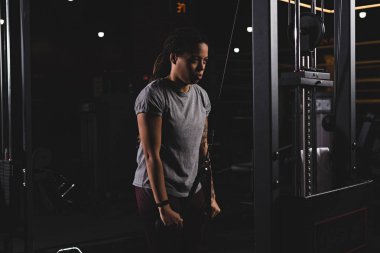 young african american girl with tattoo exercising in gym 