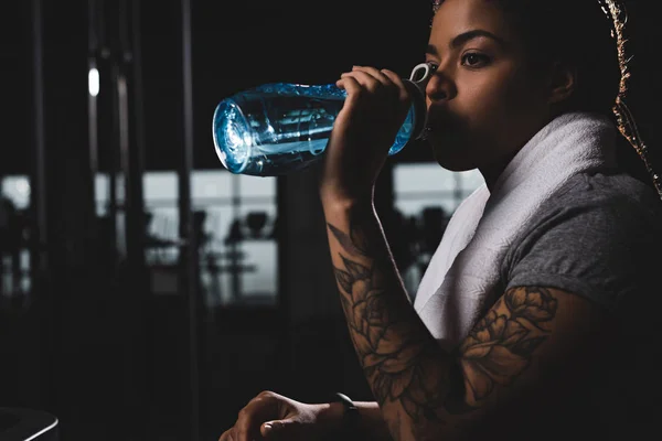 Afroamericana Chica Con Tatuaje Beber Agua Mientras Celebración Deportes Botella —  Fotos de Stock