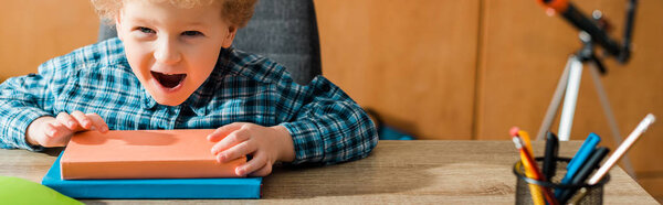 панорамный снимок счастливого умного ребенка трогательных книг
 