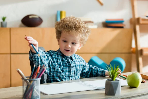 Selective Focus Smart Curly Kid Taking Pencil Ripe Apple Table — Stock Photo, Image