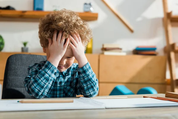 Selective Focus Upset Kid Touching Curly Hair Pencil Paper Table — Stock Photo, Image