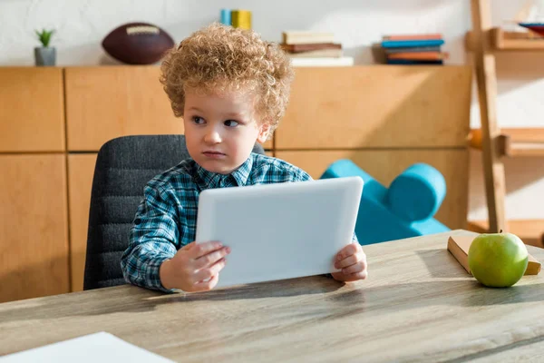 Niño Inteligente Rizado Sosteniendo Tableta Digital Cerca Del Escritorio —  Fotos de Stock