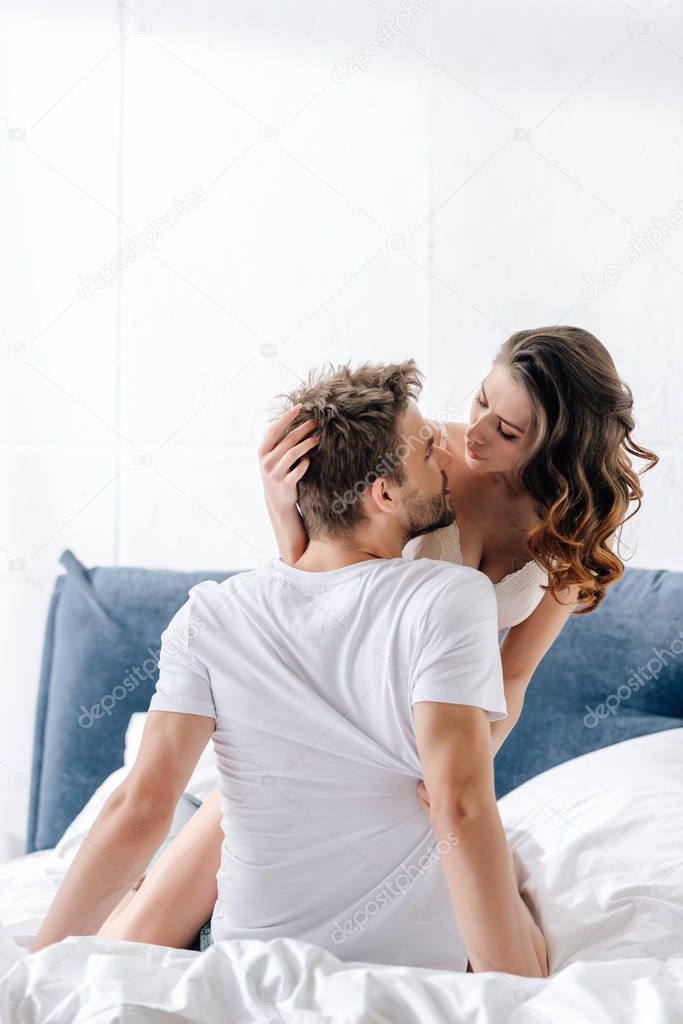 sexy girlfriend in white bra hugging and looking at boyfriend  