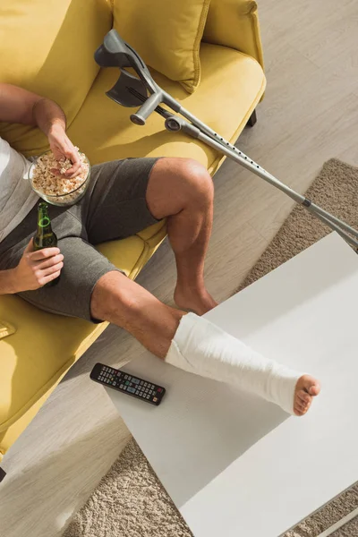 Top View Man Broken Leg Coffee Table Drinking Beer Eating — Stockfoto